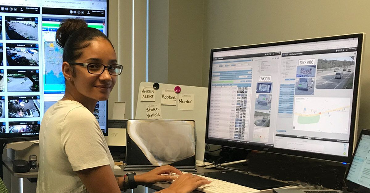 image of woman in front of three screens typing on a keyboard